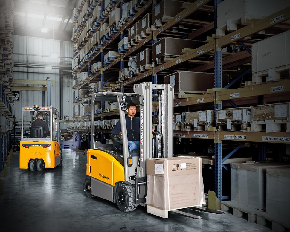 Jungheinrich electric forklifts carrying loads between warehouse storage racks