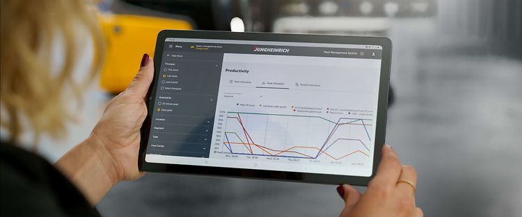 Kvinde med ipad viser Jungheinrich Fleet Management System