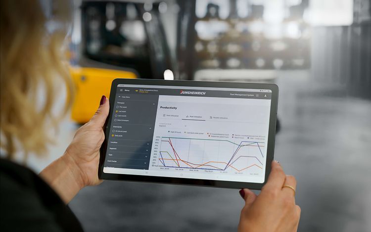 Kvinde med ipad viser Jungheinrich Fleet Management System