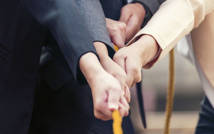 Business women pull a rope as a team_[MAM-62784]