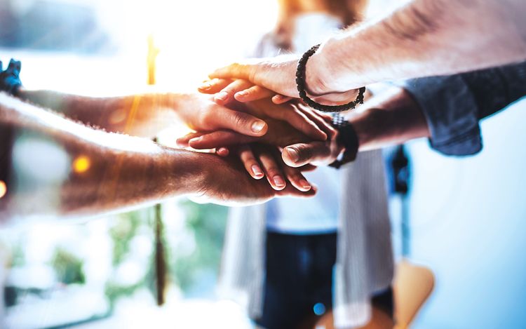 Team putting their hands on top of each other_[MAM-60128] (1)