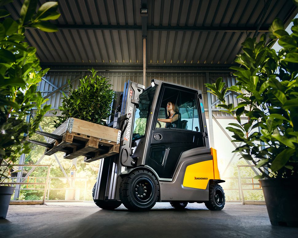 Gul motviktstruck från Jungheinrich i grönskande miljö