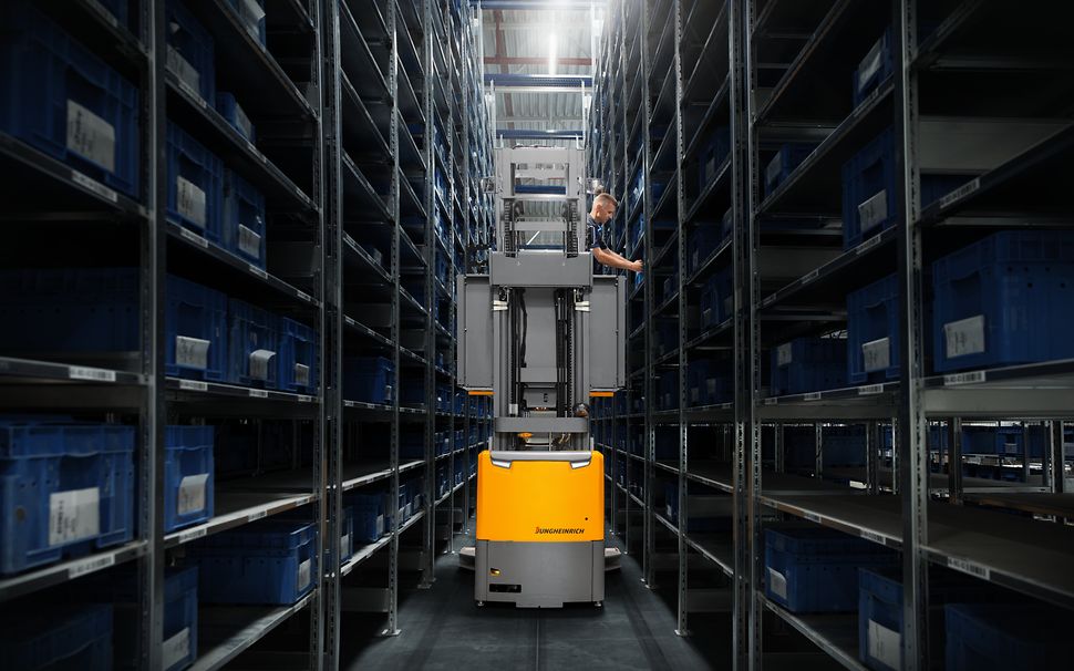 Man som plockar varor på ett lager i en Jungheinrich höglyftande plocktruck EKX 412s.