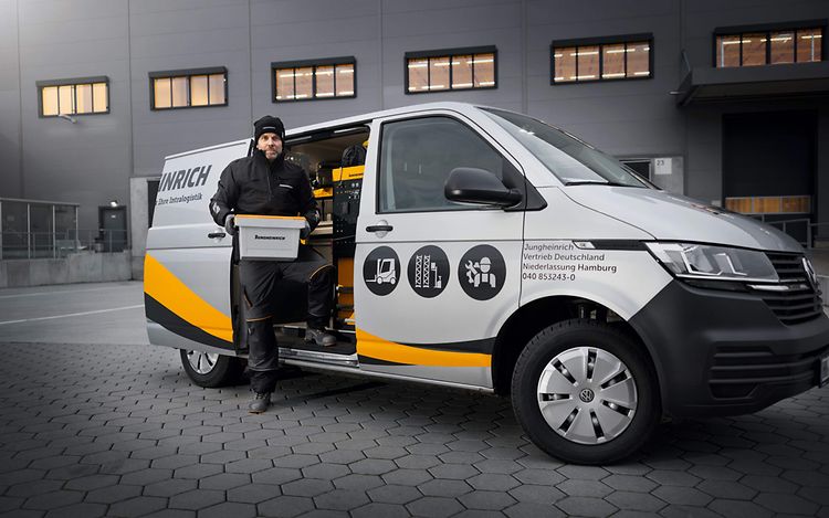 Jungheinrich servicetekniker står ved servicebil med reservedele