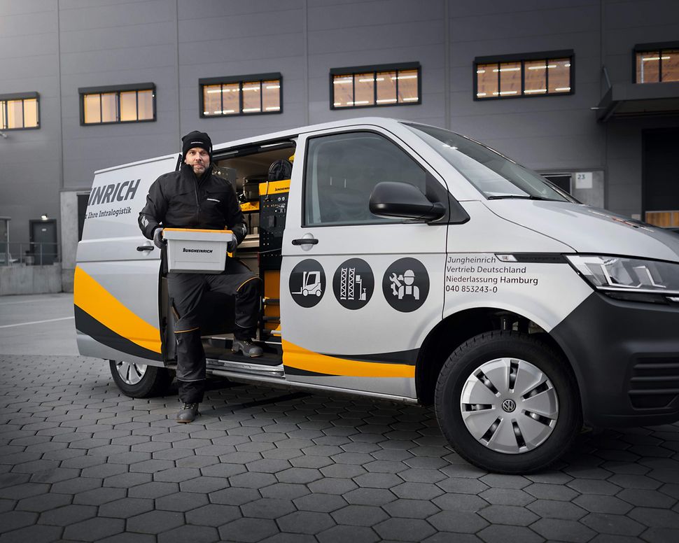 Jungheinrich servicetekniker står ved servicebil med reservedele