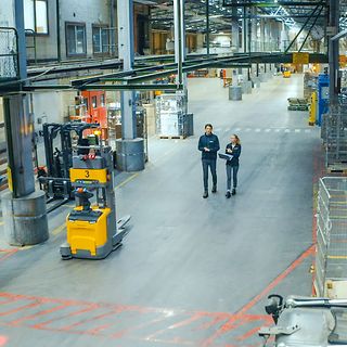 Jungheinrich AGV och två människor på DB Schenkers terminal i Borås.