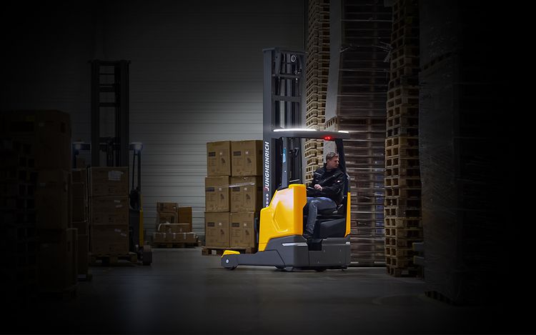 Jungheinrich skjutstativtruck ETV lyfter en lastpall högt upp i ett ställage på ett laget.