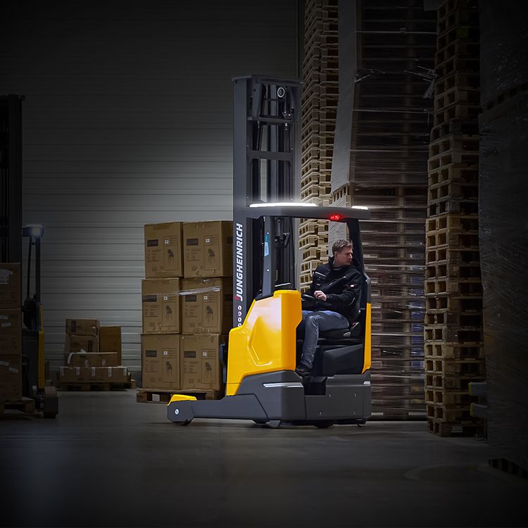 Jungheinrich skjutstativtruck ETV lyfter en lastpall högt upp i ett ställage på ett laget.