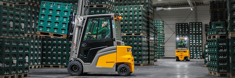 Jungheinrich eltruck EFG 430 transporterar en lastpall med dryckesbackar i ett lager.