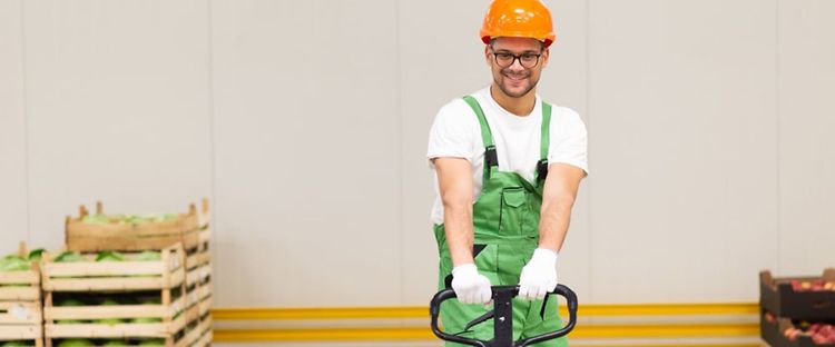 Man med manuell pallyftare i arbete