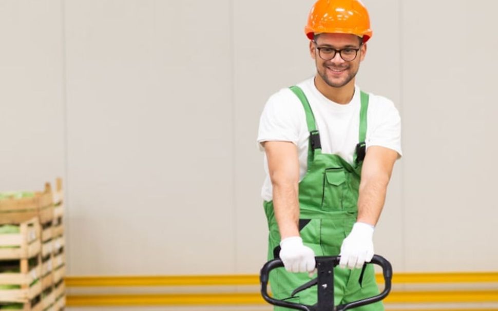 Man med manuell pallyftare i arbete