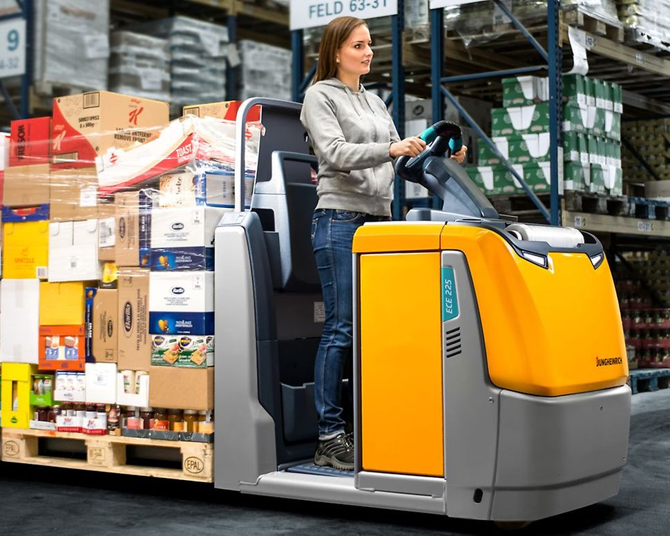  Jungheinrich plukketruck ECE 225, lastet med varer, kører rundt på et lager.