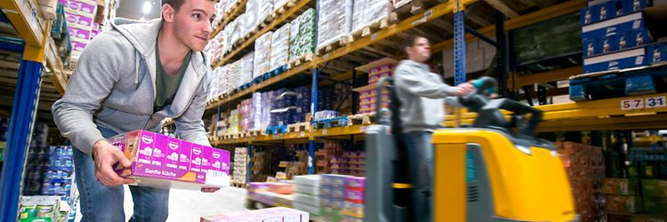  Personale, der plukker varer ved hjælp af en Jungheinrich plukketruck på et lager.