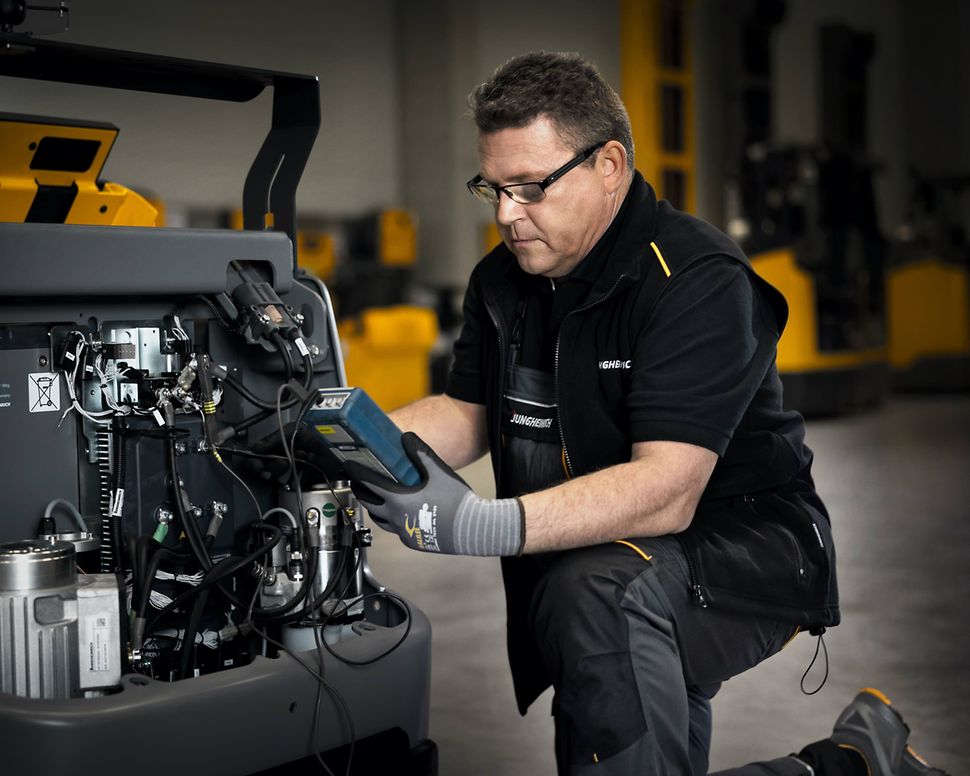 Jungheinrich service engineer carrying out maintenance on a forklift truck