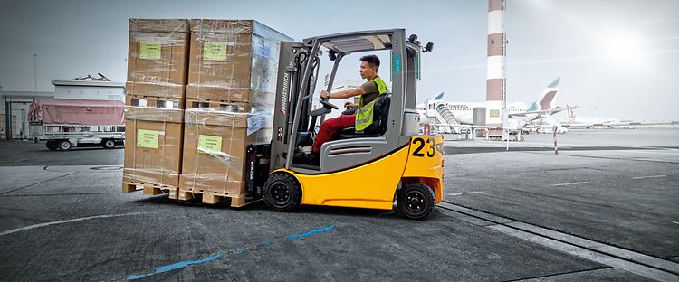 Jungheinrich begagnad motviktstruck med pallar på en flyplats.