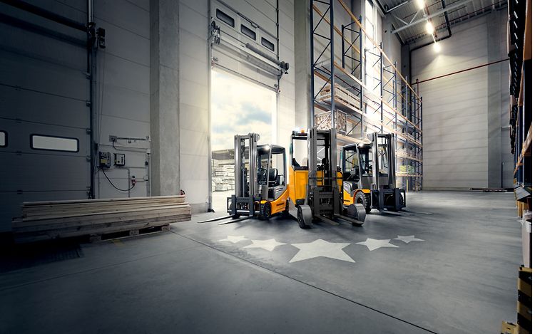 Foto präsentiert Jungheinrichs überholte JUNGSTAR Fahrzeuge. Auf dem Boden vor den Fahrzeugen sind Sterne abgebildet.