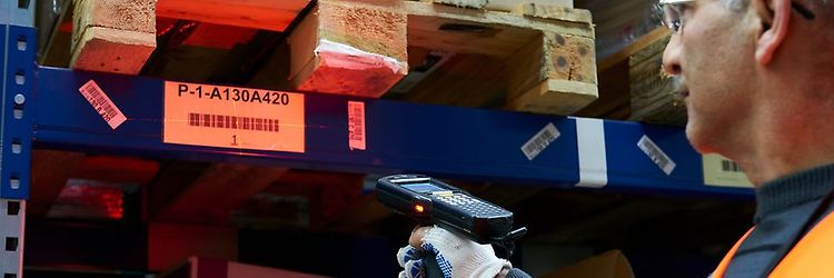 Mand står ved en pallehylde og holder en håndscanner fra Jungheinrich.