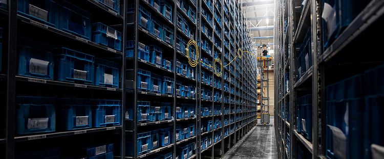 Man kører en højløftende plukketruck i et halvautomatisk lager fra Jungheinrich.