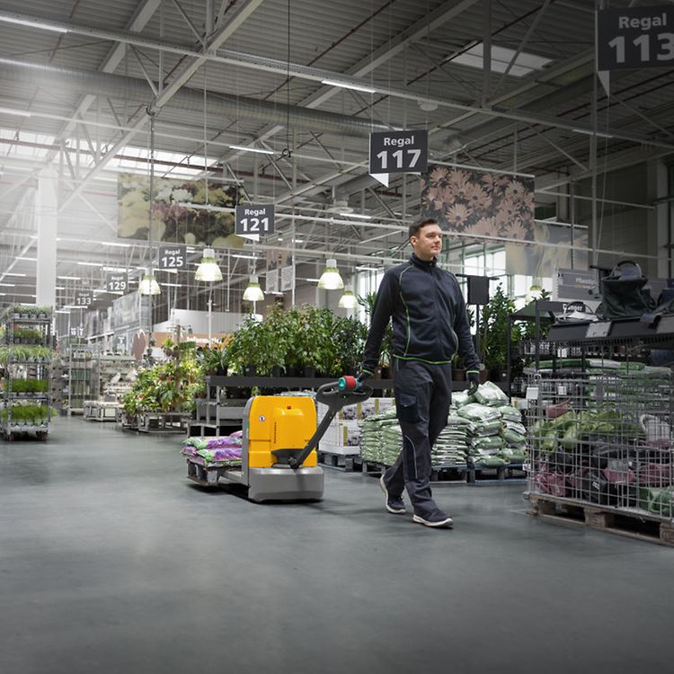 Mand i butik kører med el palleløfter AME fra Jungheinrich