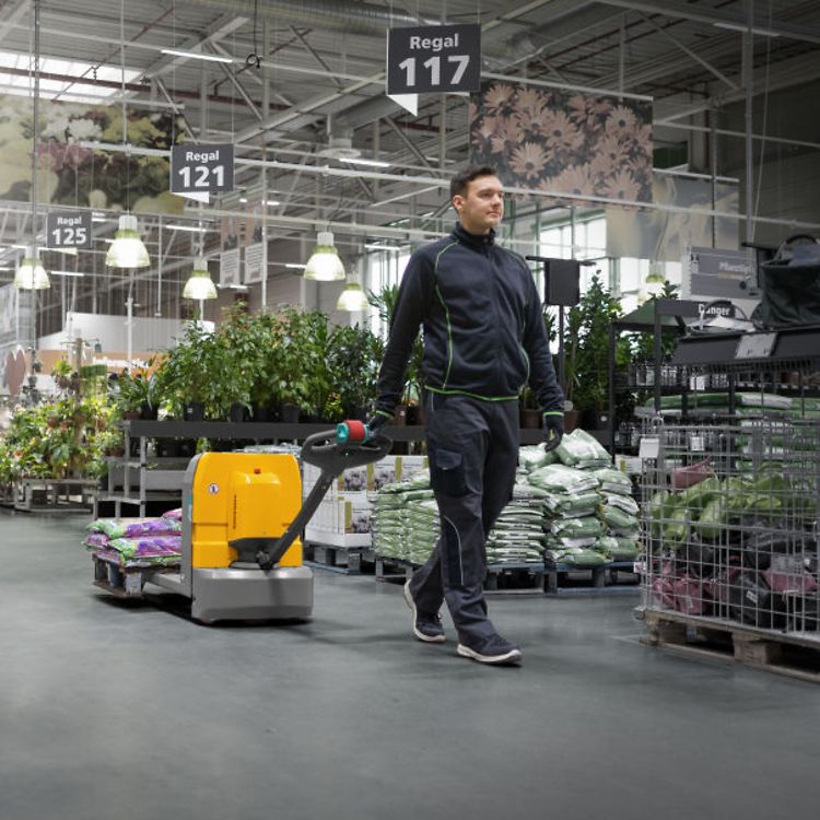 En man i butik kör en låglyftare AME från Jungheinrich