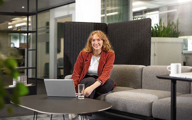 Lea Cordes is sitting on a sofa in front of her laptop