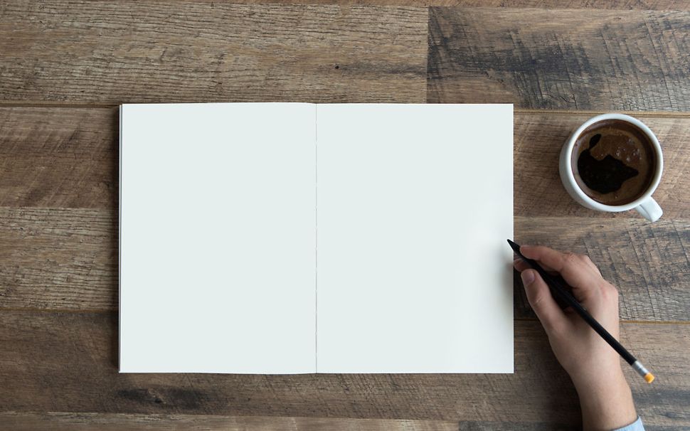 A hand holds a pen and is ready to write in a book_57416 (1)