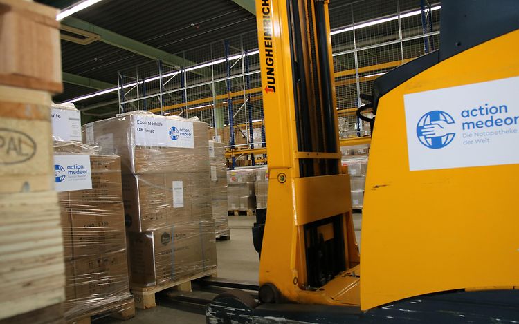 A yellow forklift truck is lifting a pallet of crates.