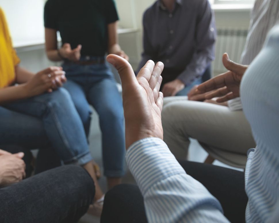 Menschen sitzen in einem Stuhlkreis