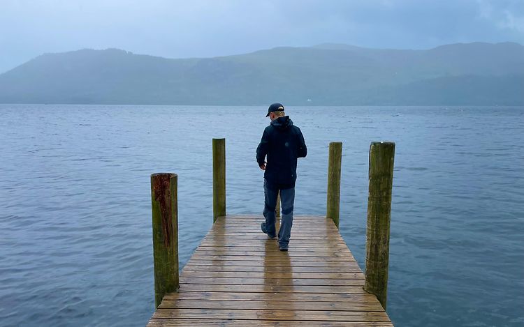 Mats is standing on a jetty with his back to the camera. There is a lake in the background.