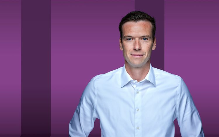 Torsten Gerhardt steht vor einem lila-Hintergrund.