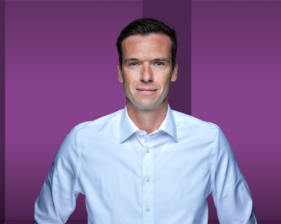 Torsten Gerhardt is standing against a purple background.