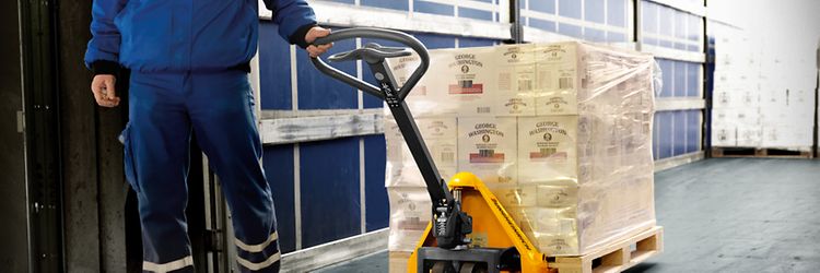Pracownik magazynu obsługujący paleciak ręczny – jungheinrich.pl